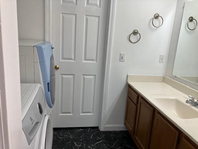 bathroom with marble finish floor, washer and dryer, and vanity