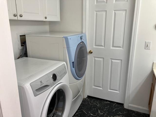 laundry area featuring marble finish floor, cabinet space, and washer and clothes dryer