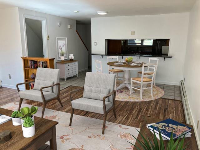 living area with baseboards and wood finished floors