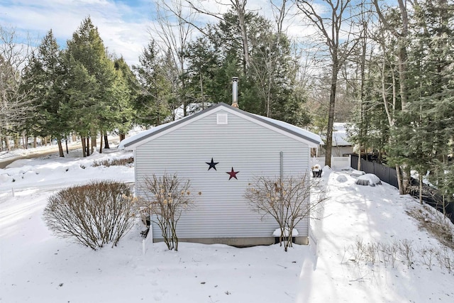 snow covered property with a garage and fence