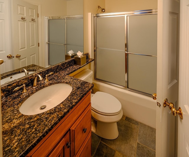 full bath featuring toilet, enclosed tub / shower combo, and vanity