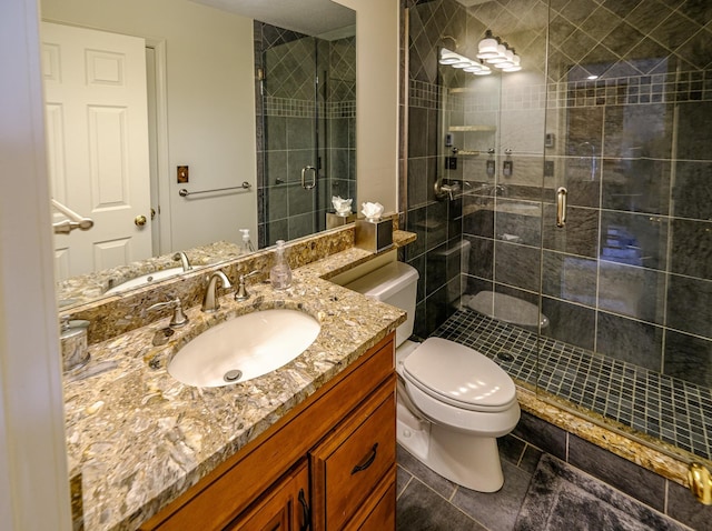 bathroom with toilet, a stall shower, and vanity