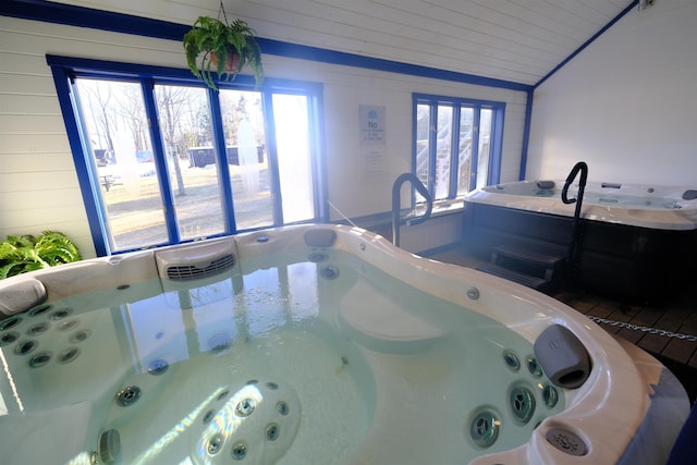 interior space with lofted ceiling, wooden ceiling, and a hot tub