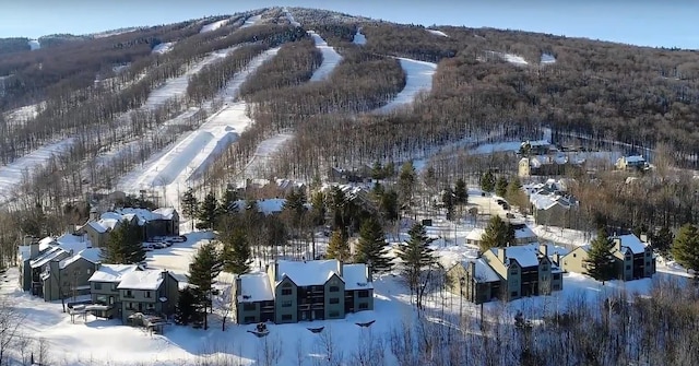 snowy aerial view featuring a residential view and a mountain view