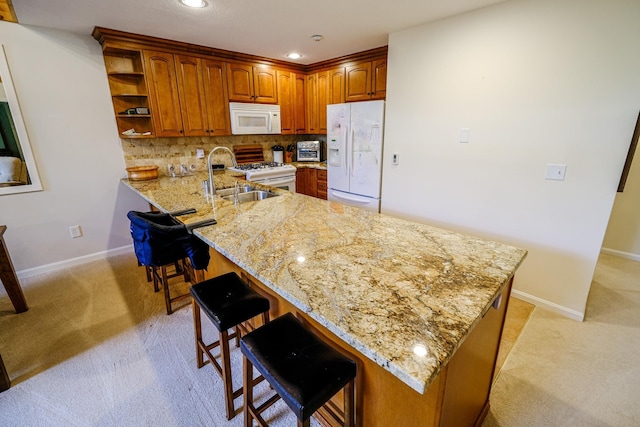 kitchen with a peninsula, white appliances, a kitchen bar, and open shelves