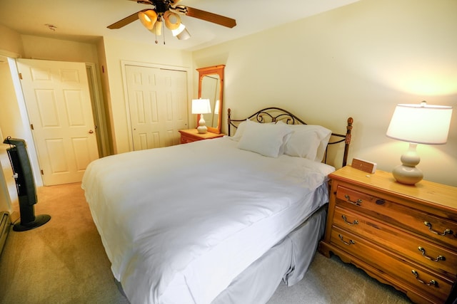 bedroom with a ceiling fan, a closet, and light colored carpet