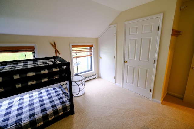 bedroom featuring vaulted ceiling, multiple windows, baseboard heating, and light colored carpet