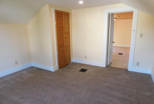 additional living space with baseboards, visible vents, lofted ceiling, carpet floors, and recessed lighting