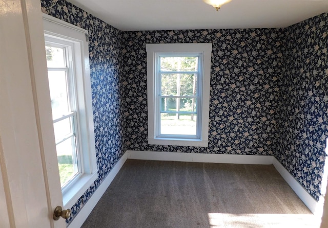 empty room featuring baseboards, plenty of natural light, and wallpapered walls