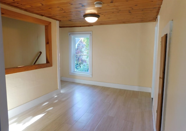 spare room featuring wood ceiling, baseboards, and light wood-style flooring