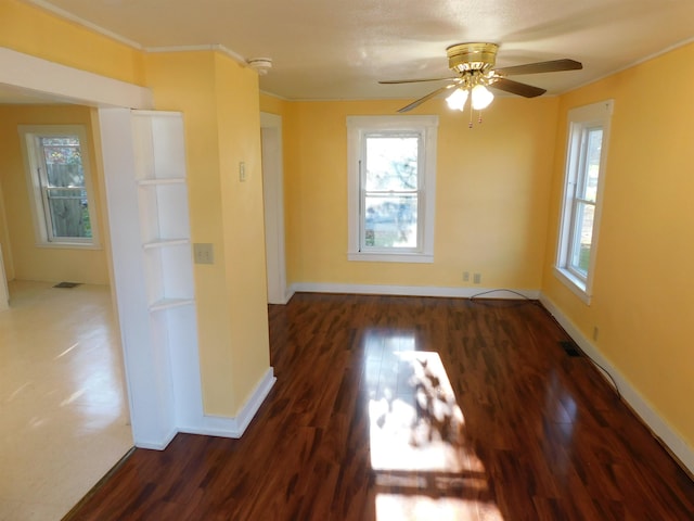 unfurnished room featuring ceiling fan, dark wood-type flooring, visible vents, and baseboards