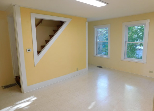 additional living space featuring visible vents, baseboards, and stairs