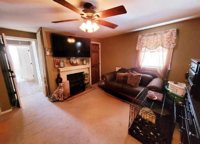 living area featuring a fireplace, a ceiling fan, and carpet floors