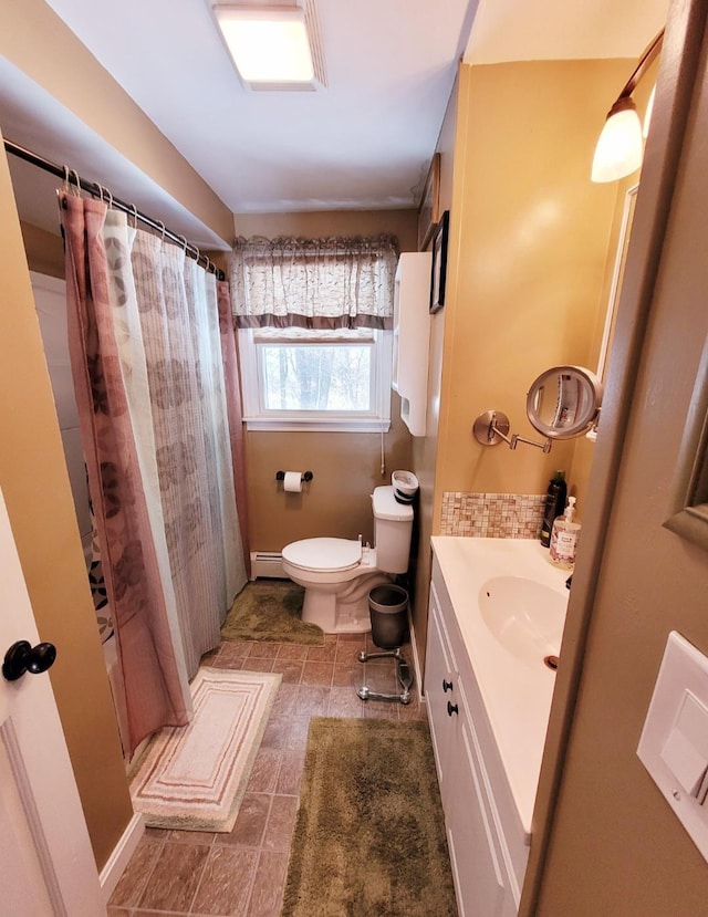 full bathroom featuring toilet, vanity, and a baseboard radiator