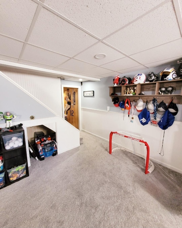 playroom with a drop ceiling, carpet, and wainscoting