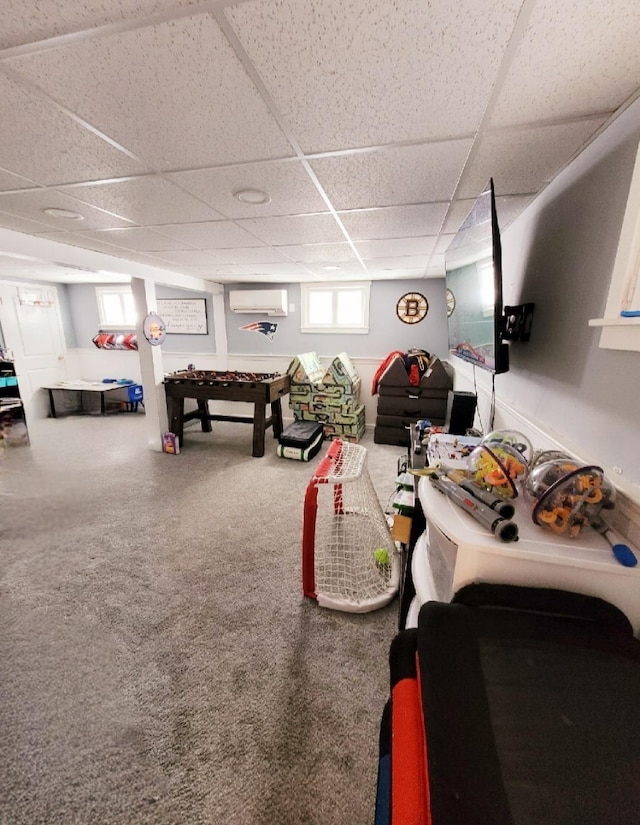 interior space with carpet, an AC wall unit, and a paneled ceiling