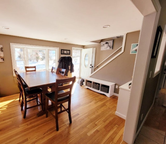 dining space featuring light wood-style flooring and baseboards