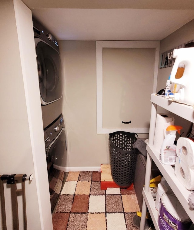 laundry room with laundry area, baseboards, and stacked washing maching and dryer