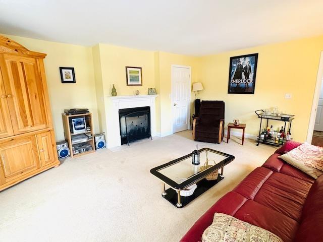 carpeted living room with a fireplace