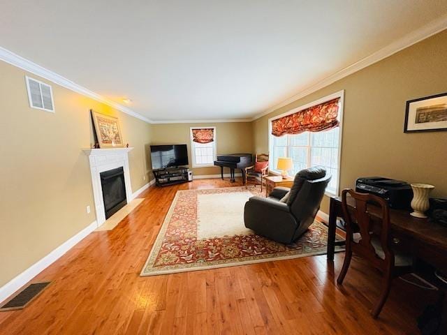 living room featuring a fireplace with flush hearth, visible vents, and wood finished floors