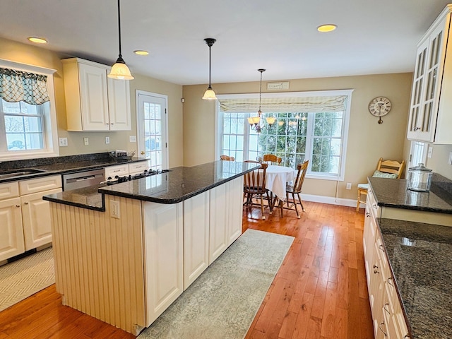 kitchen featuring light wood-style floors, glass insert cabinets, and a wealth of natural light