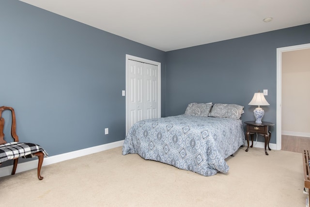 carpeted bedroom featuring a closet and baseboards