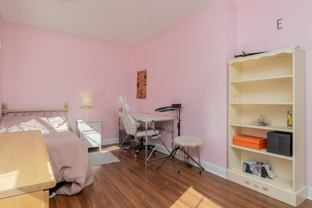 bedroom with baseboards and wood finished floors