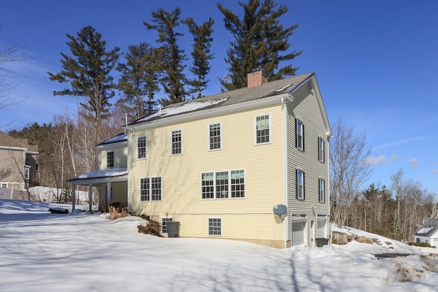 snow covered property with a chimney