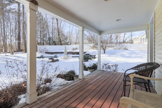 snow covered deck featuring fence