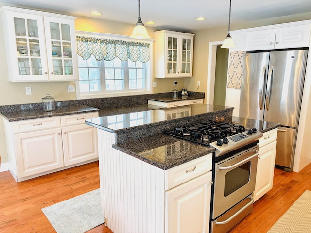 kitchen featuring recessed lighting, hanging light fixtures, light wood-style flooring, appliances with stainless steel finishes, and a kitchen island