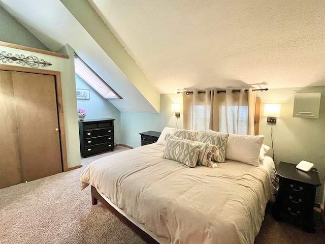 bedroom with carpet floors, lofted ceiling with skylight, and a textured ceiling