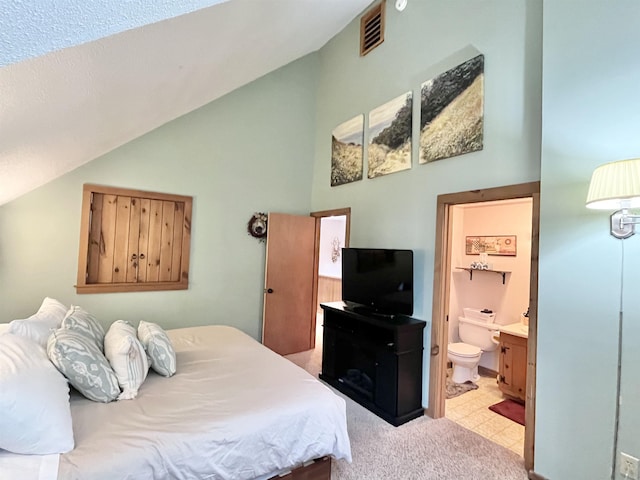 bedroom featuring visible vents, vaulted ceiling, and ensuite bathroom