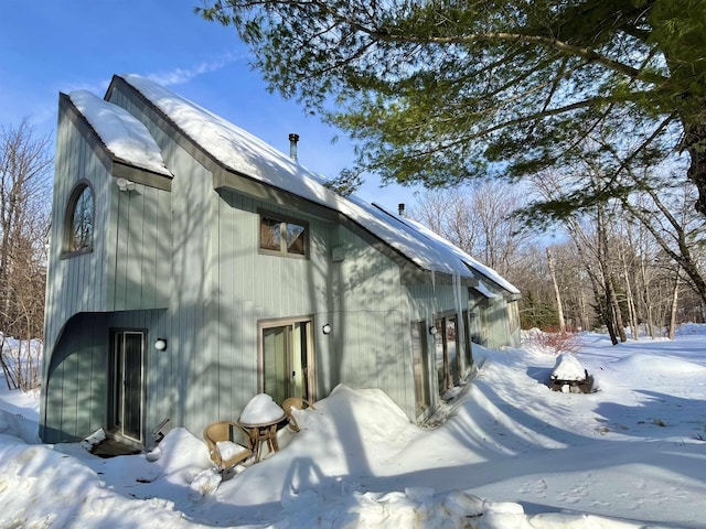 snow covered property featuring entry steps