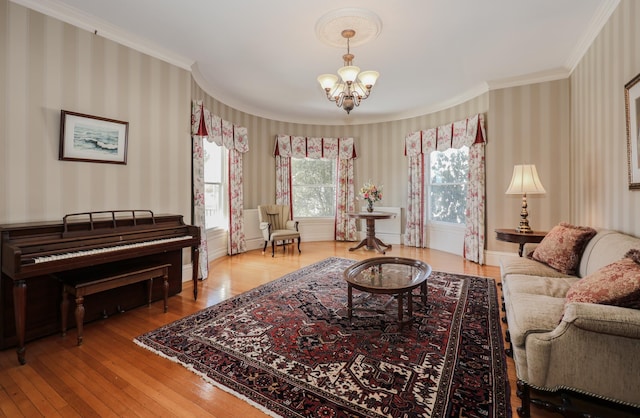 living area featuring wallpapered walls, a notable chandelier, and crown molding