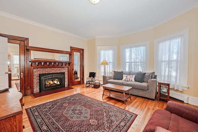 living room featuring a brick fireplace, crown molding, and hardwood / wood-style flooring