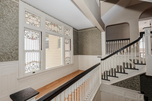 hallway featuring wallpapered walls and a wainscoted wall