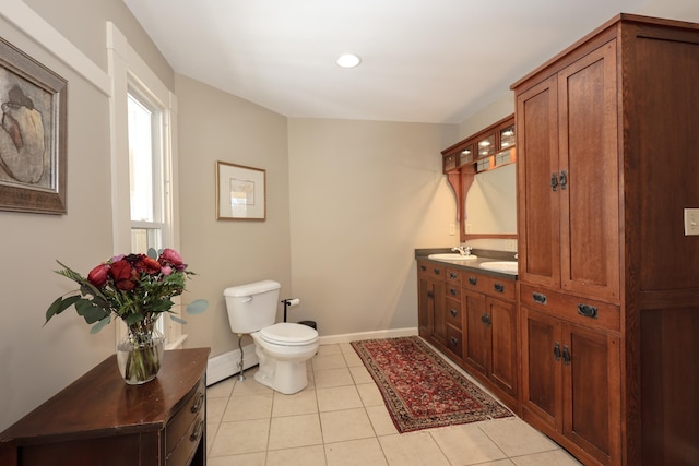 bathroom featuring a baseboard radiator, tile patterned flooring, toilet, vanity, and baseboards