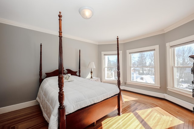 bedroom featuring ornamental molding, multiple windows, and baseboards