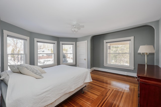 bedroom featuring parquet floors, multiple windows, and baseboards