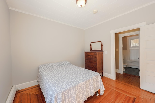 bedroom with a baseboard heating unit, ornamental molding, hardwood / wood-style flooring, and baseboards