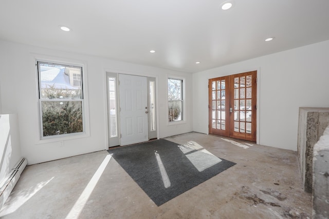 entryway featuring french doors, unfinished concrete flooring, a baseboard radiator, and a healthy amount of sunlight