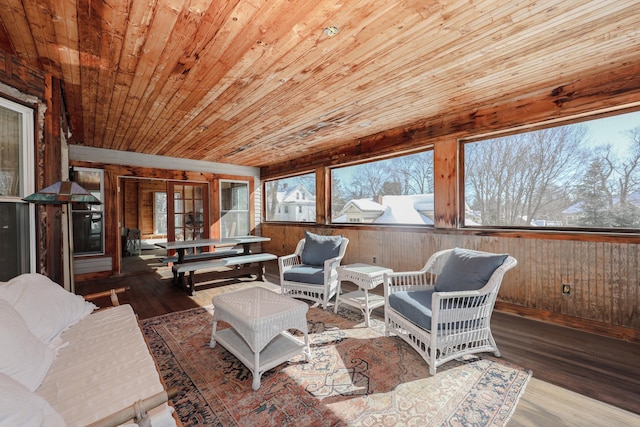 living room featuring a wealth of natural light, wooden ceiling, wooden walls, and wood finished floors