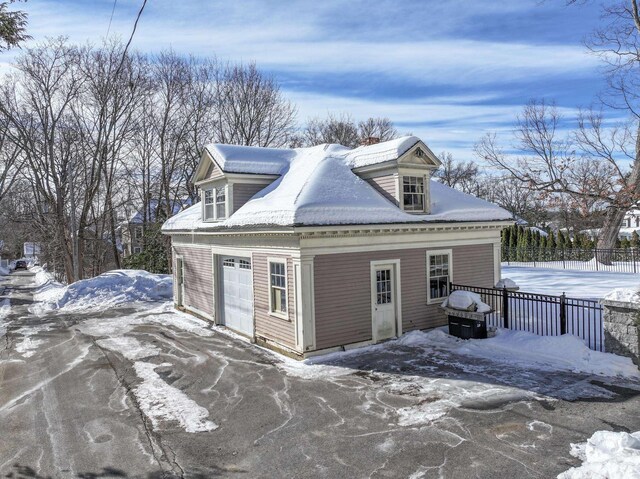 view of snow covered exterior with fence