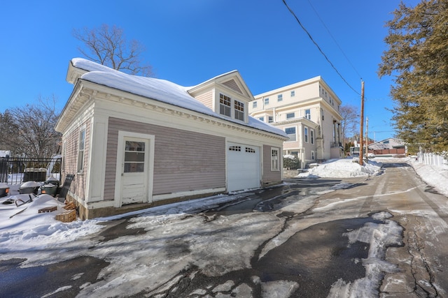 snow covered property with a garage