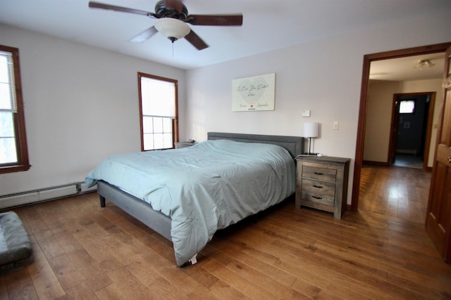 bedroom featuring baseboard heating, ceiling fan, and hardwood / wood-style floors