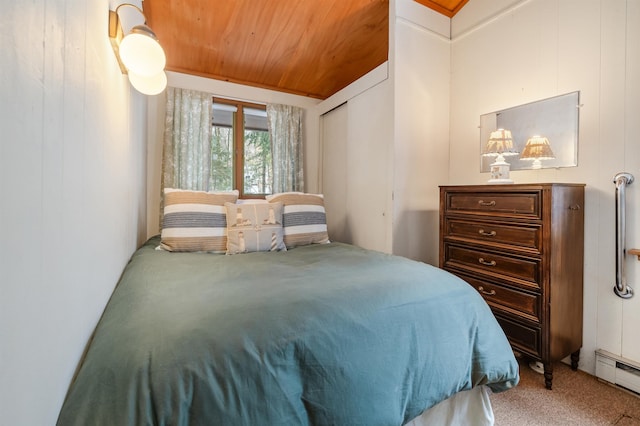 carpeted bedroom featuring a baseboard radiator and wooden ceiling