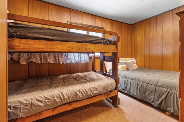 carpeted bedroom featuring wooden walls