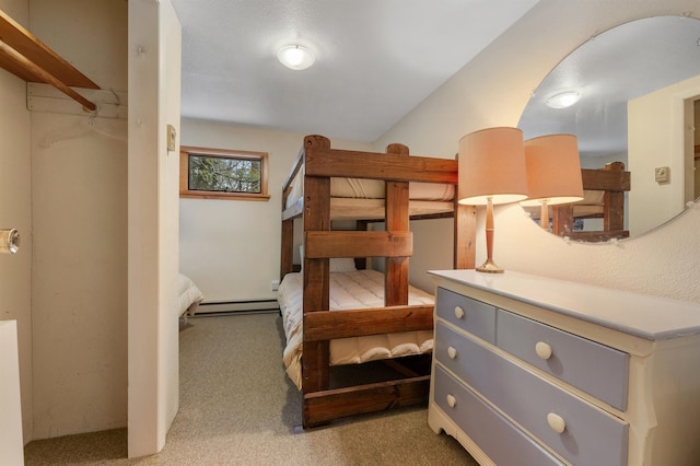 bedroom with baseboard heating and carpet