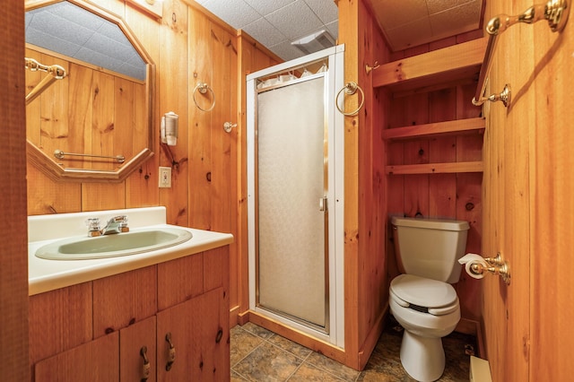 full bathroom featuring wood walls, a shower stall, and toilet