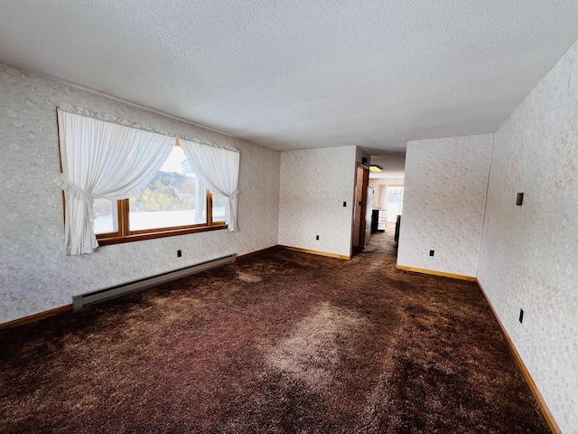 unfurnished room with a baseboard heating unit, a textured ceiling, and wallpapered walls